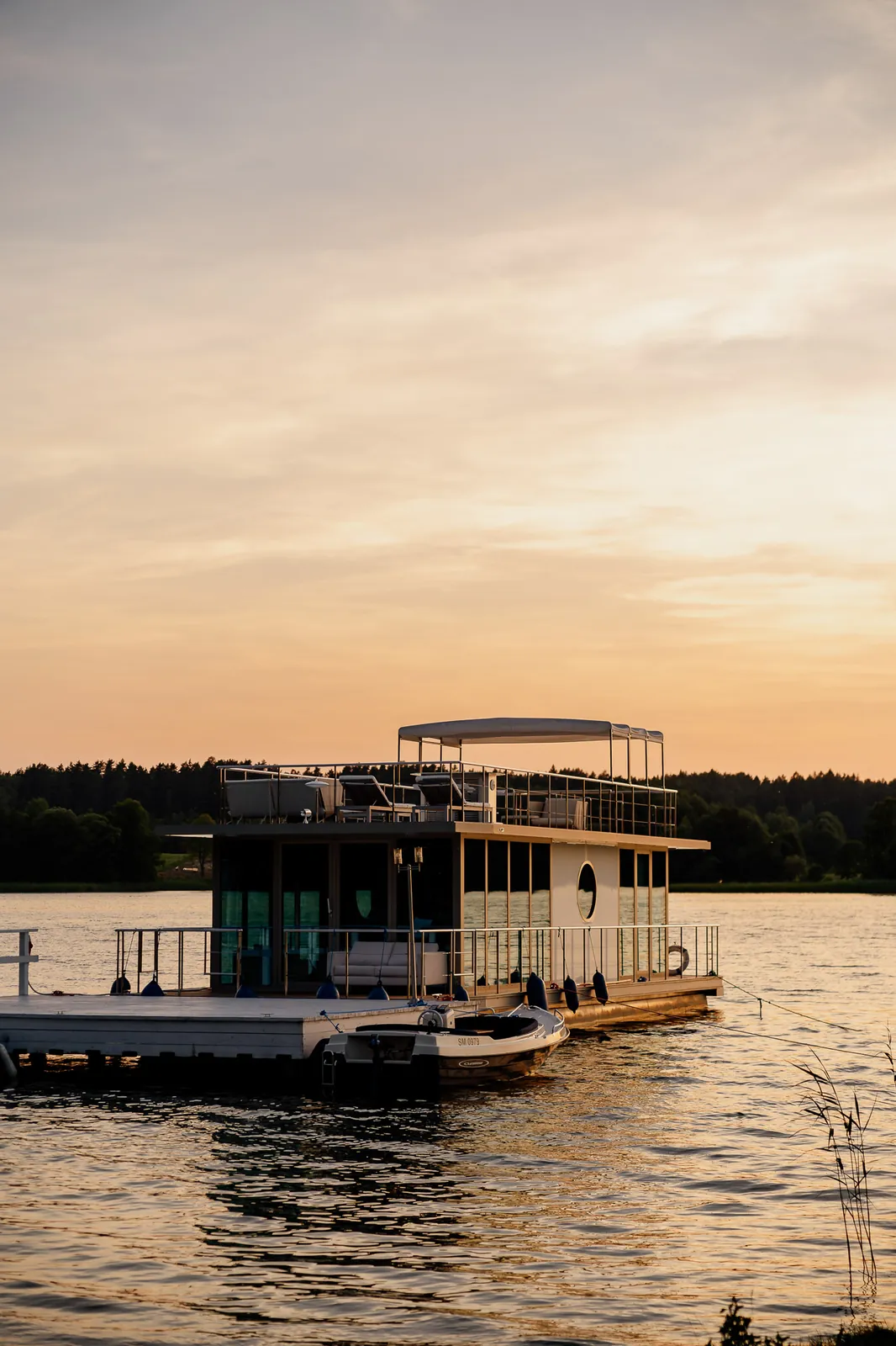 Barka na jeziorze o zachodzie słońca — Narie Resort & Spa; fotografia obiektów nad wodą, kadr pionowy
