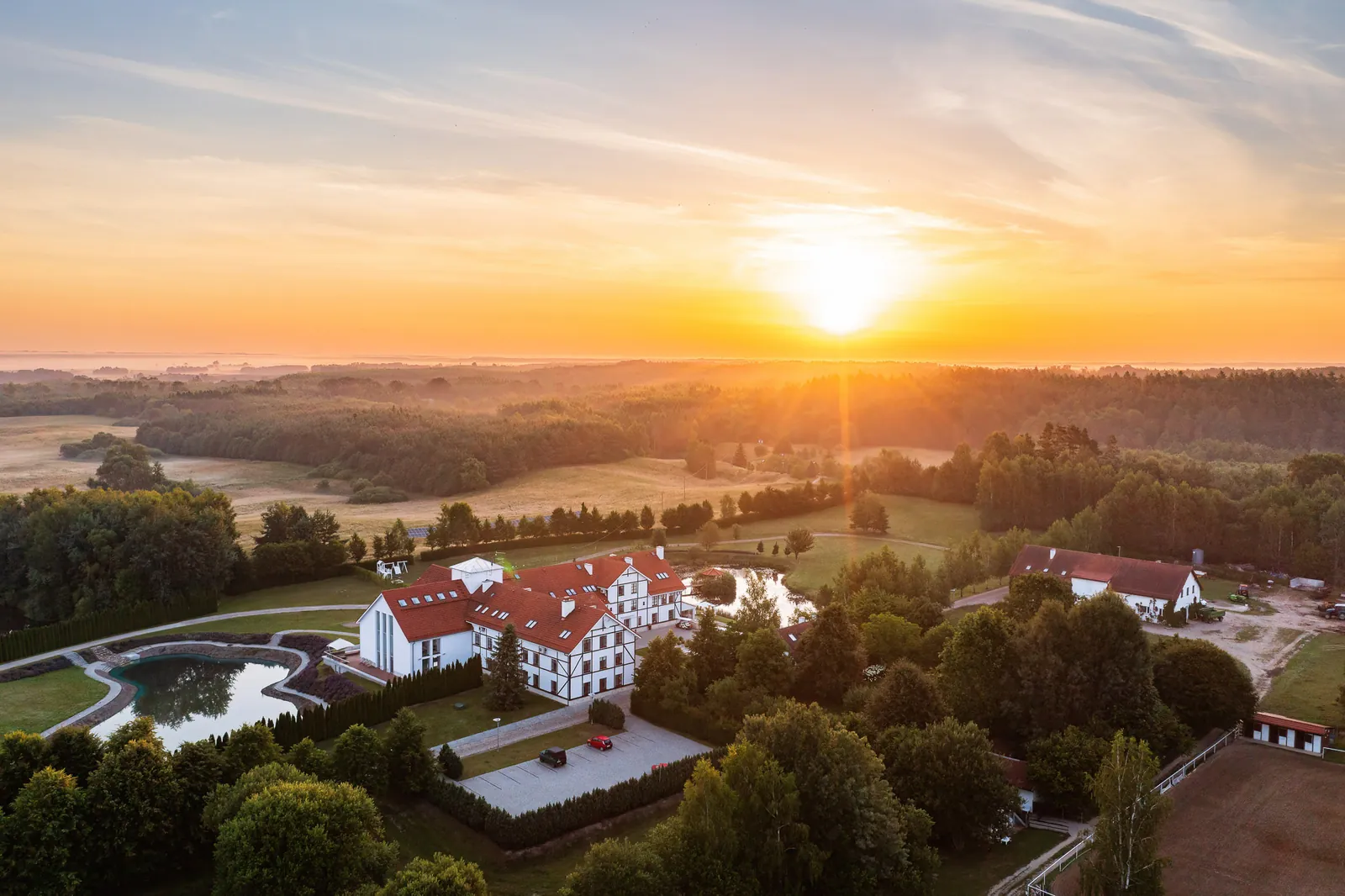 Hotel nad jeziorem z drona przed zachodem słońca — Narie Resort & Spa, okolice Morąga; fotografia hoteli z drona, Warmia i Mazury