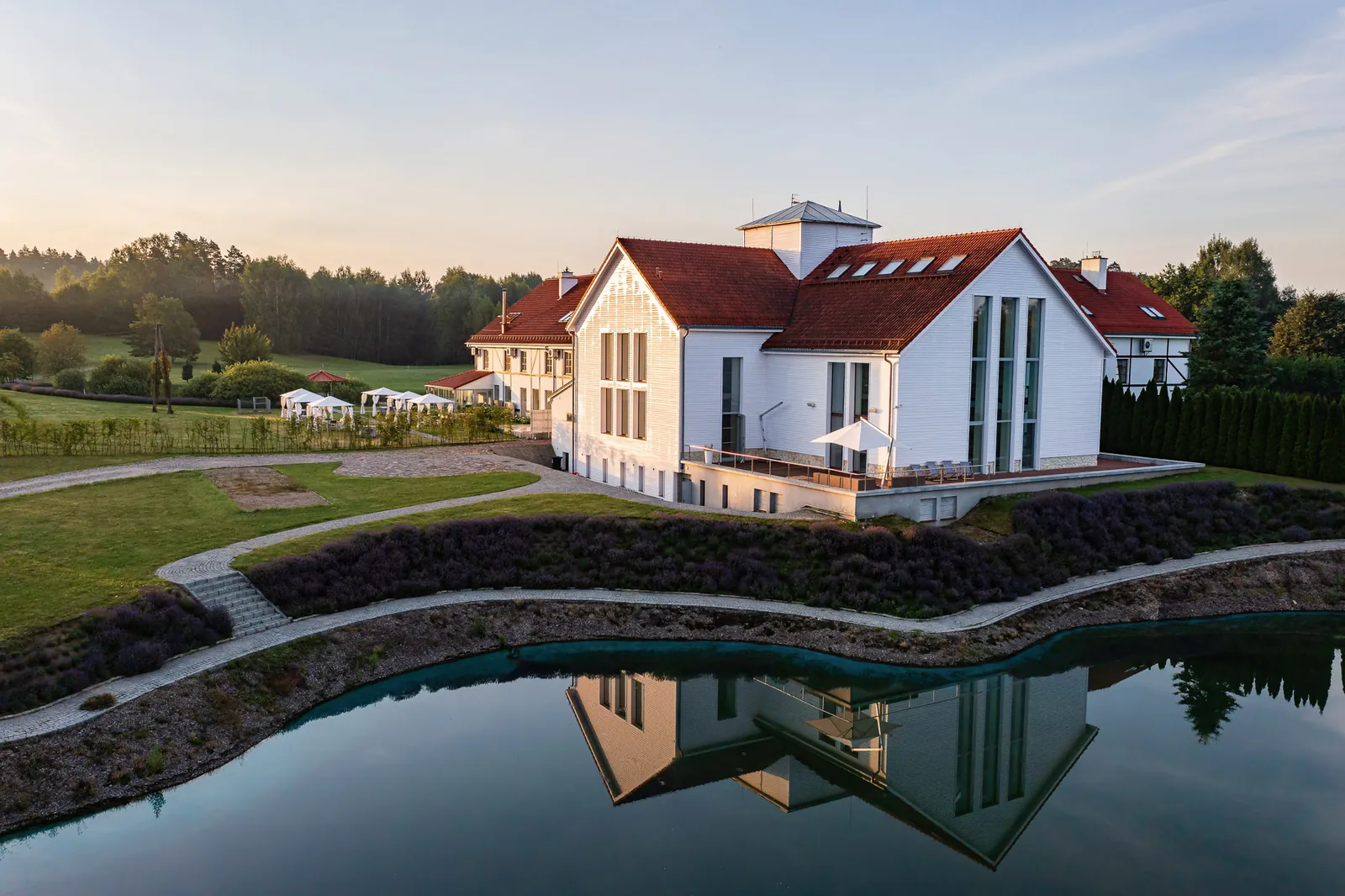 Hotel z odbiciem w tafli jeziora — ujęcie z drona, Narie Resort & Spa, okolice Morąga; zdjęcia z drona dla hoteli