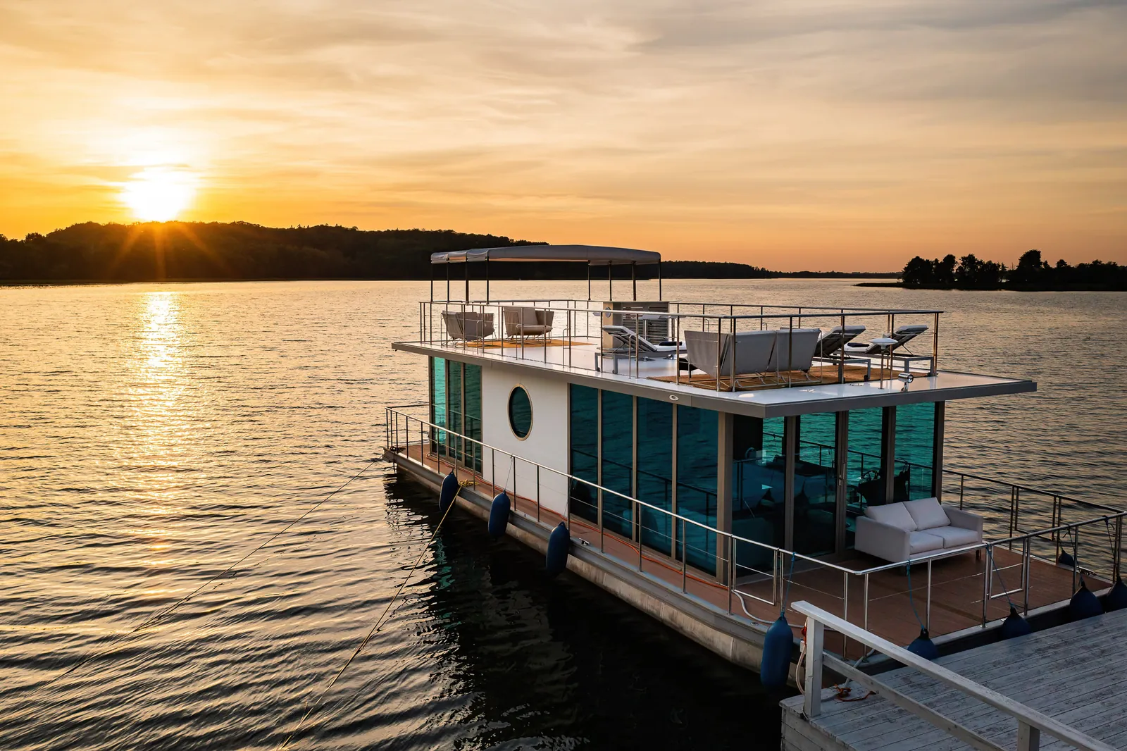 Houseboat hotelowy na jeziorze o zachodzie słońca — Narie Resort & Spa; fotografia obiektów nad wodą, Warmia i Mazury
